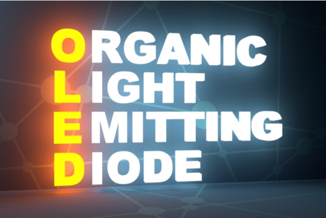 Organic light emitting diode i stora lysande bokstäver staplade på varandra mot mörk bakgrund.